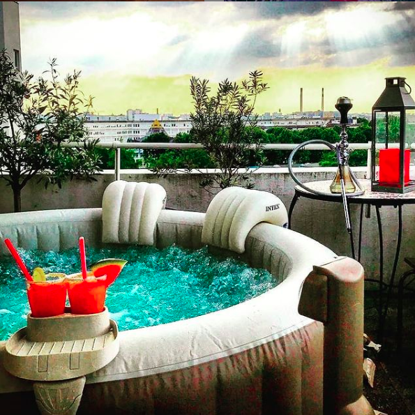 Jacuzzi sur terasse avec un narguilé et des boissons rouges